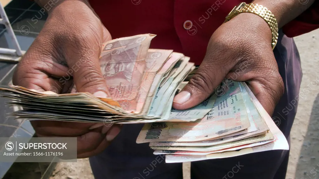 Man counting Indian rupee notes India