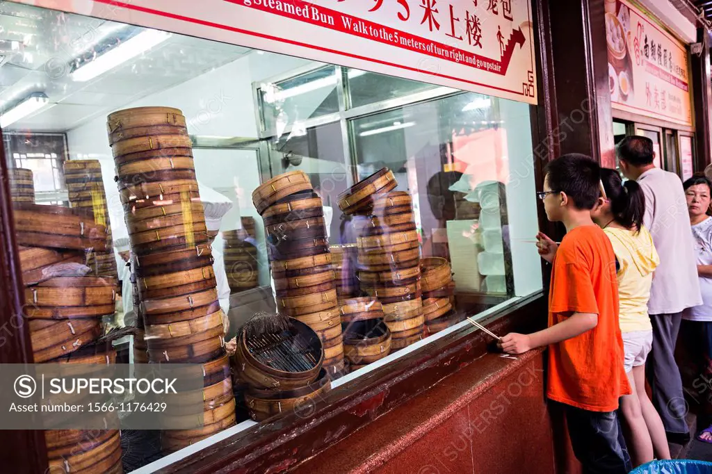 Children watch famous Nanxiang steamed buns being made in Yu Gardens bazaar Shanghai, China
