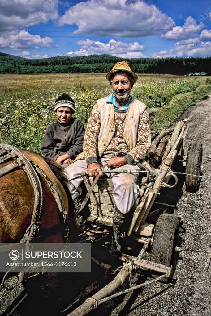 Man and son on wagon with horse in rural Macedonia.