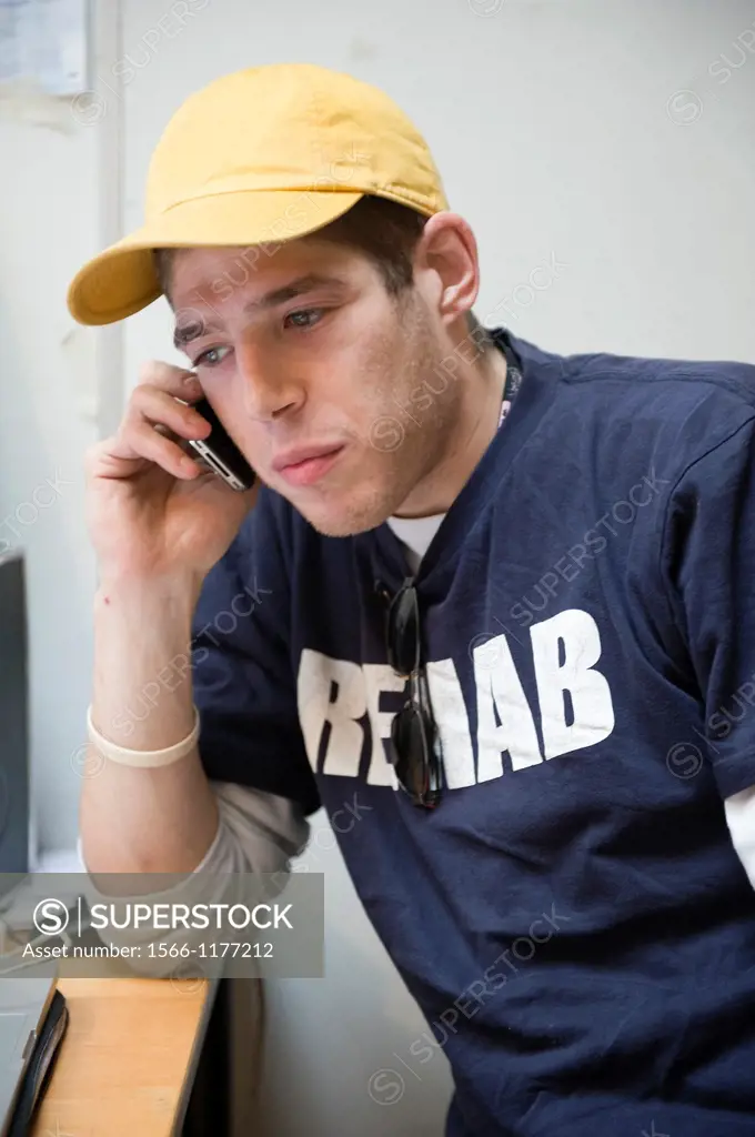 Rotterdam, Netherlands. Young, English employee of a gallery making a phone-call in the office.