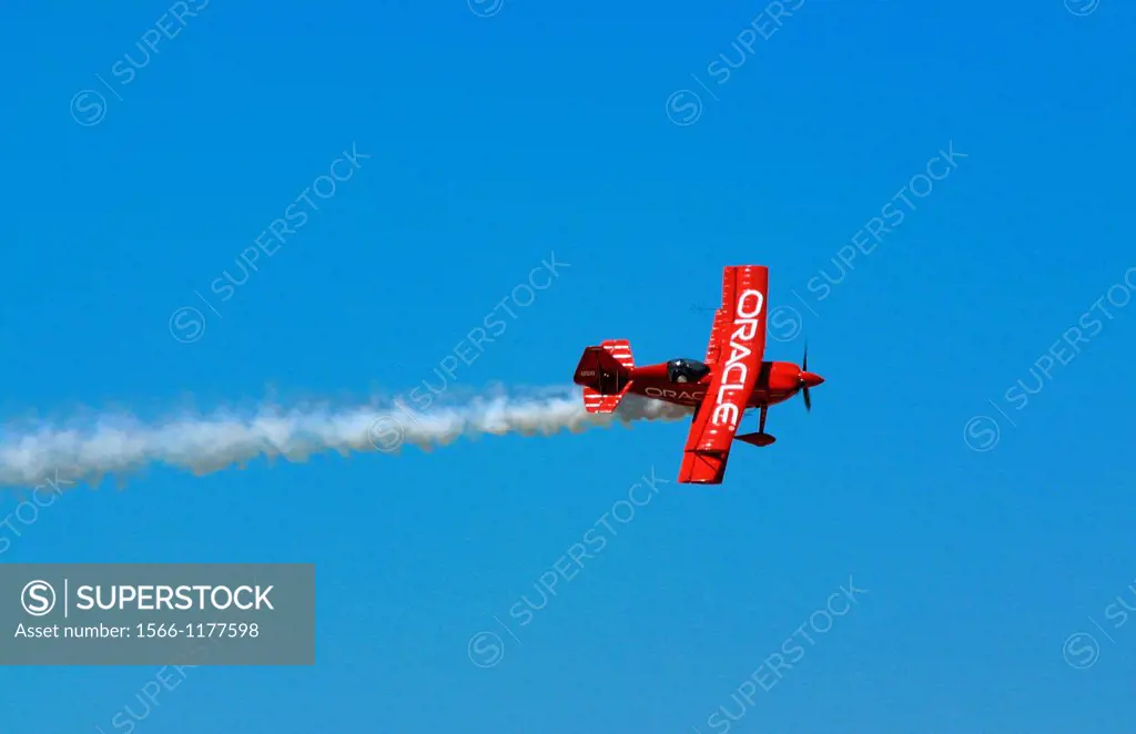 Sean Tucker flies his bright Orange Oracle Challenger through the blue sky over the crowds at Dayton Ohio