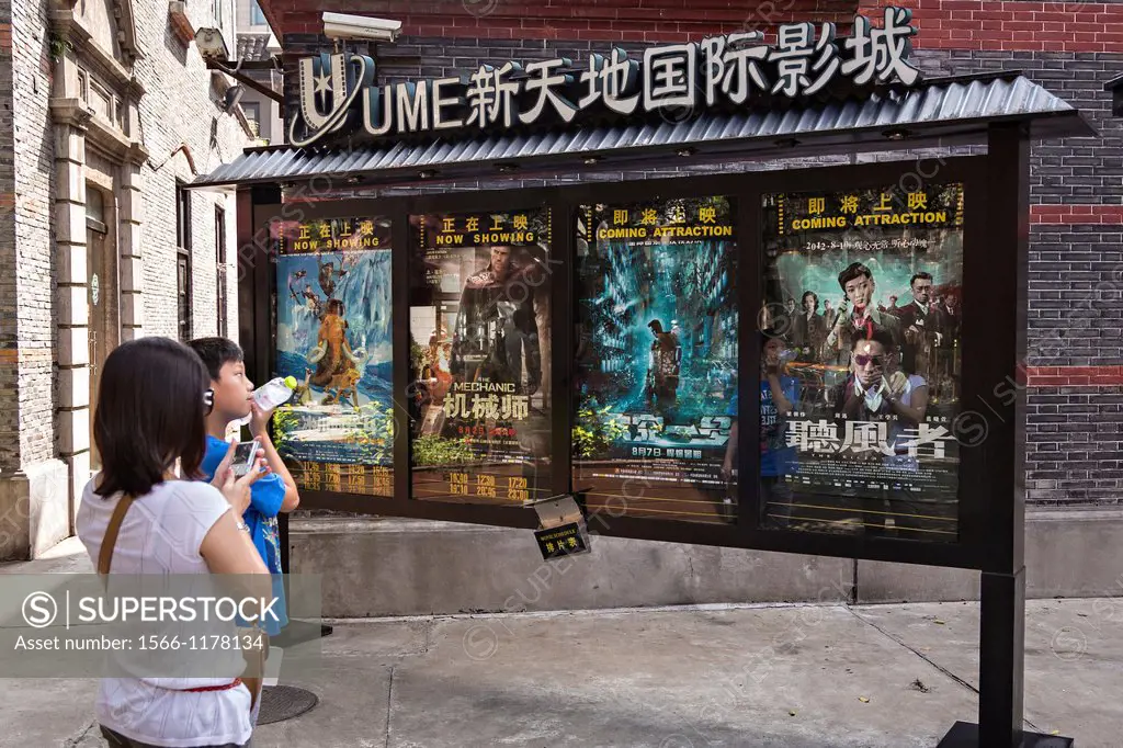 A mother and son view movie posters in Xintiandi Plaza shopping district Shanghai, China