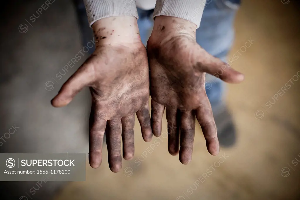 Hand of a ten years old boy dirty with black paint
