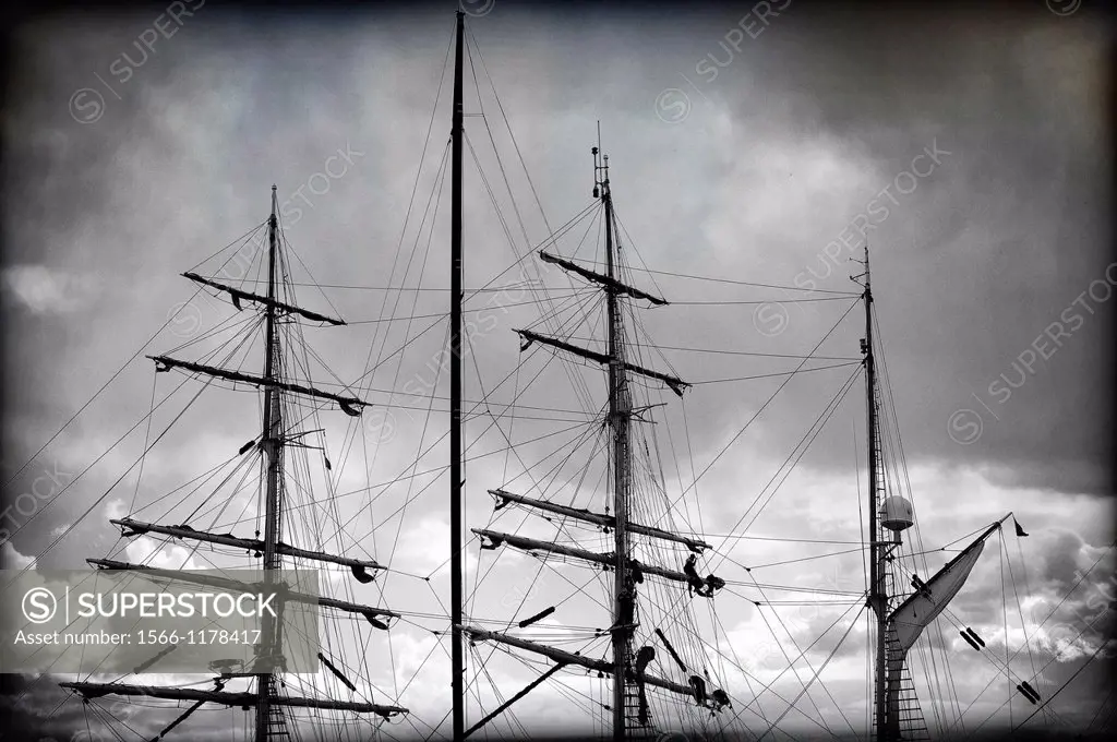 Detalle de marineros trabajando en los mastiles de un barco de epoca, Detail of sailors working on the masts of a vintage yacht,