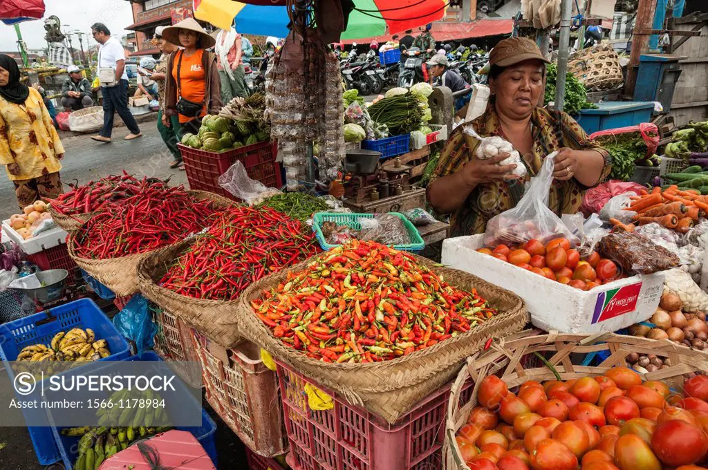 Woman selling chilli peppeers and vegetables, at the Pasar Badung market in Denpasar, Bali, Indonesia