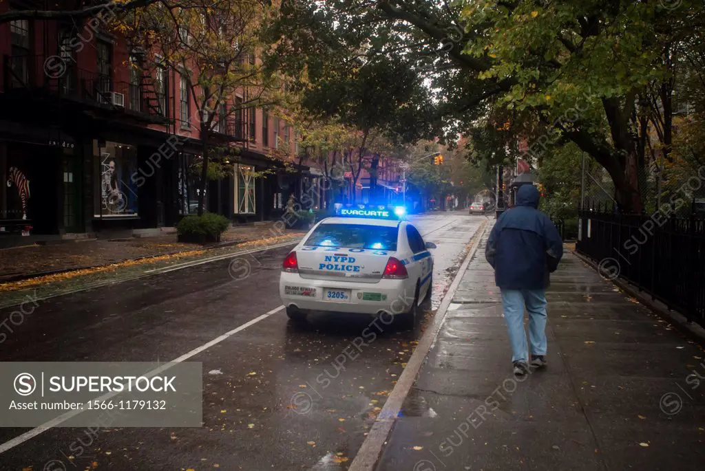 A police car parked on Bleecker Street in the Greenwich Village neighborhood of New York encourages residents to evacuate Hurricane Sandy continues it...
