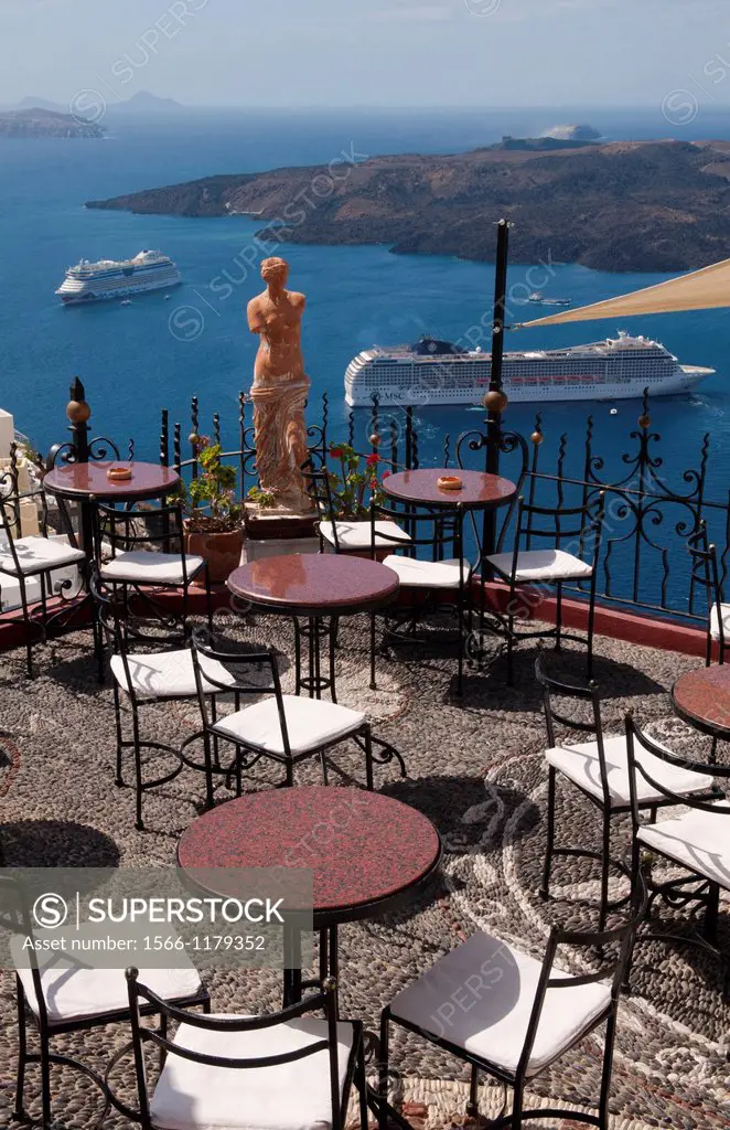 Looking down at romantic restaurant and the sea with statue in Santorini Greece in Greek Islands
