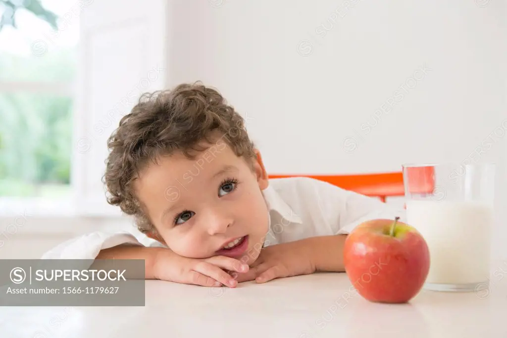 Four year old boy with milk and fruit for beakfast
