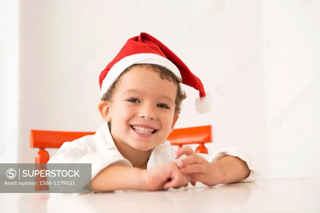 Four year old boy wearing a santa hat at Christmas