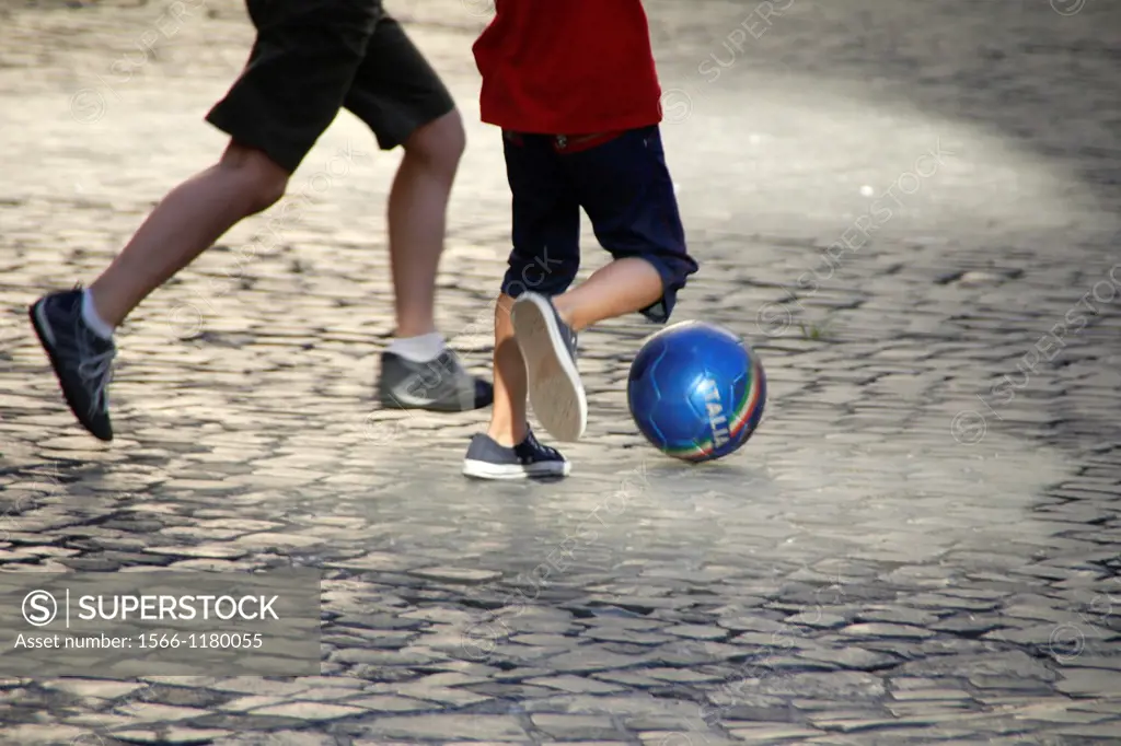 children playing football in street in rome italy