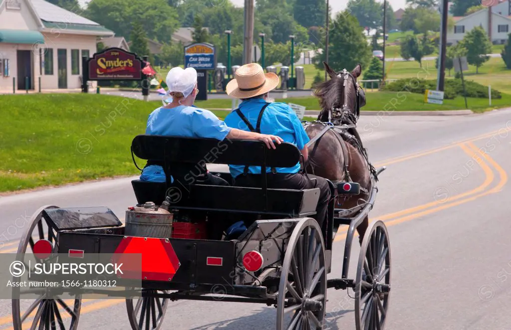 Amish couple in old fashioned horse carriage on street in Intercourse Pennsylvania in Lancaster area of Amish country