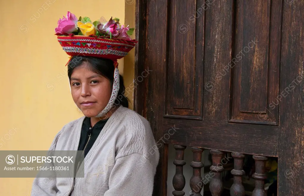 Traditional woman in colorful flower hat, in small town of Pisaq Peru