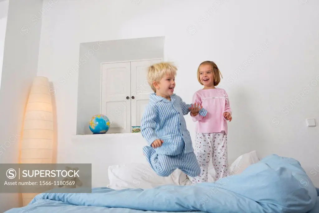 Siblings jumping on the bed