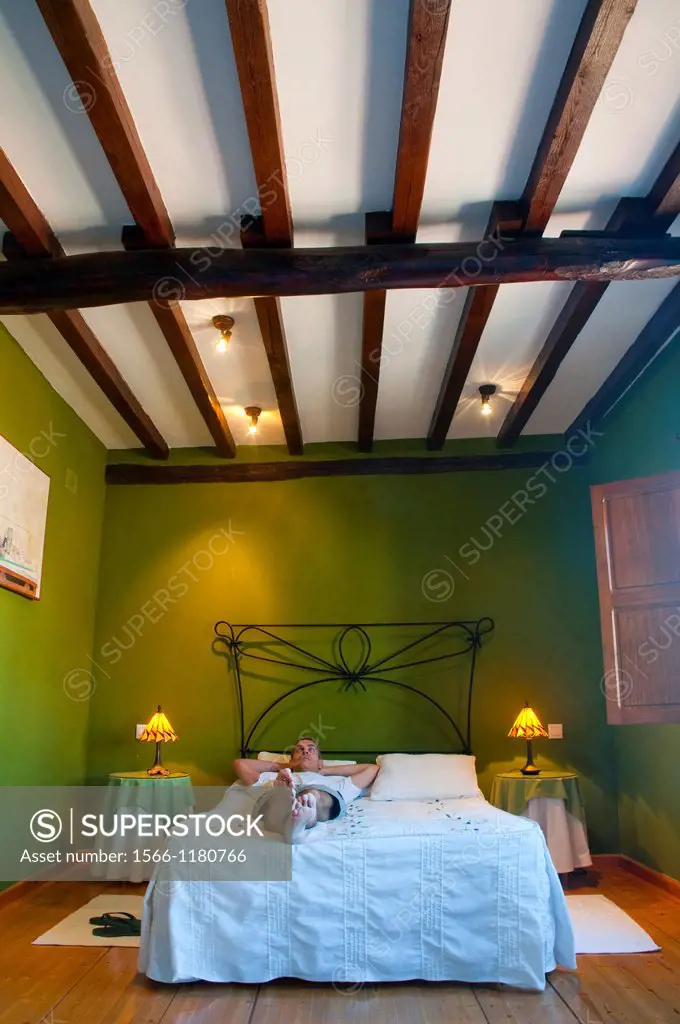 Man lying on bed in a rural hotel