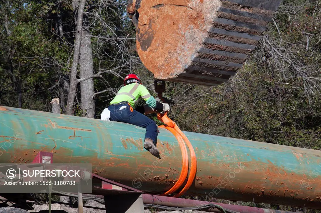 Winnsboro, Texas - A worker unloads pipe from a truck during construction of the southern portion of the Keystone XL pipeline  Environmentalists have ...