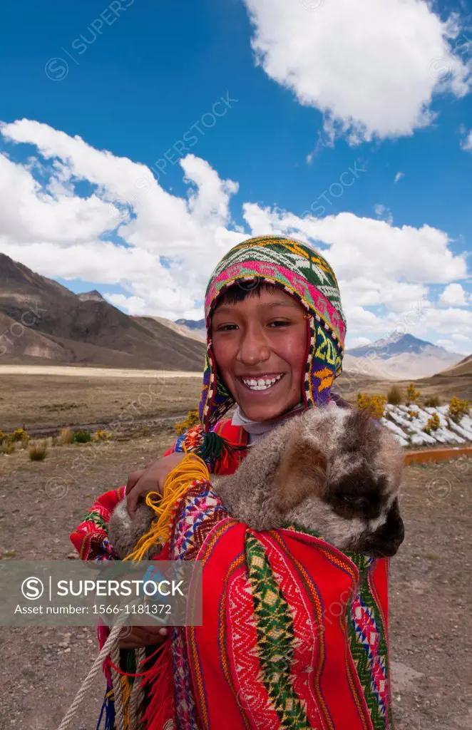 High peak at 13,000 feet of La Raya Peru with young boy with llama portrait