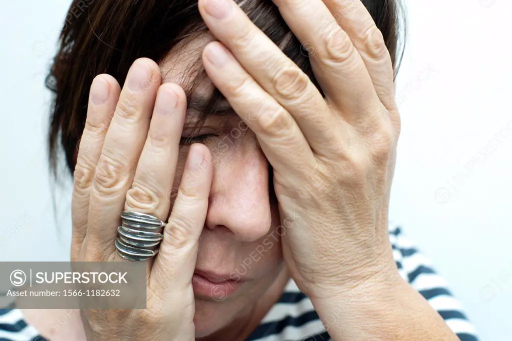 woman with her hands covering her face, worried