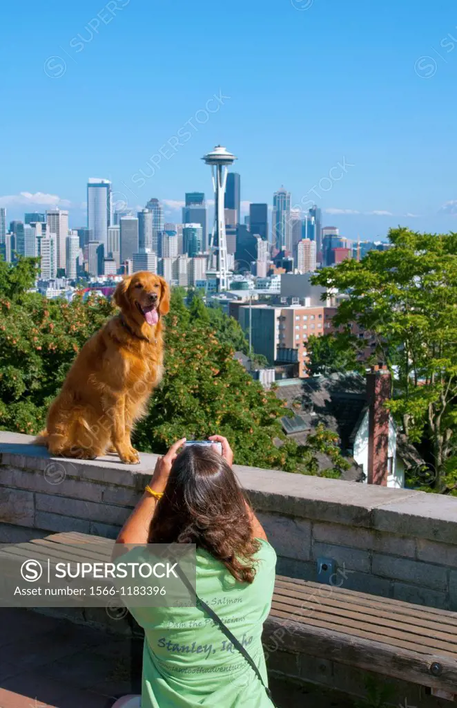 Seattle, Washington skyline from Queen Anne´s Hill with girl taking picture of dog and Mt Rainier visable in background