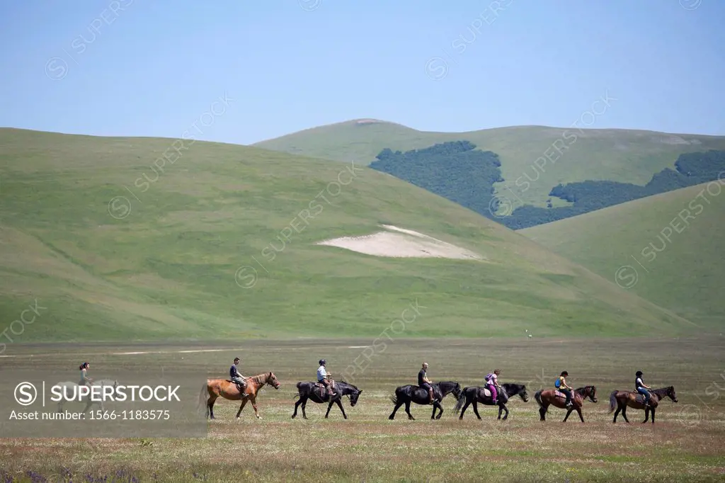 horsemen riding in open space, landscape, castelluccio di norcia, umbria, italy, europe
