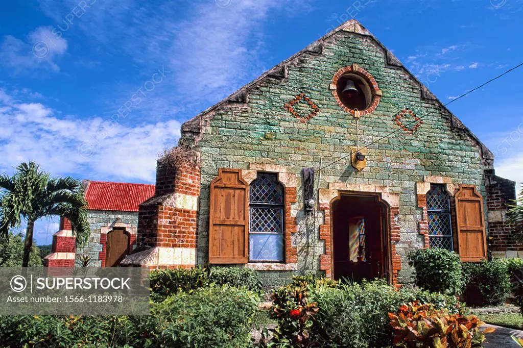 Green old St Barnabas Anglican Church with colorful gardens near St John Antigua