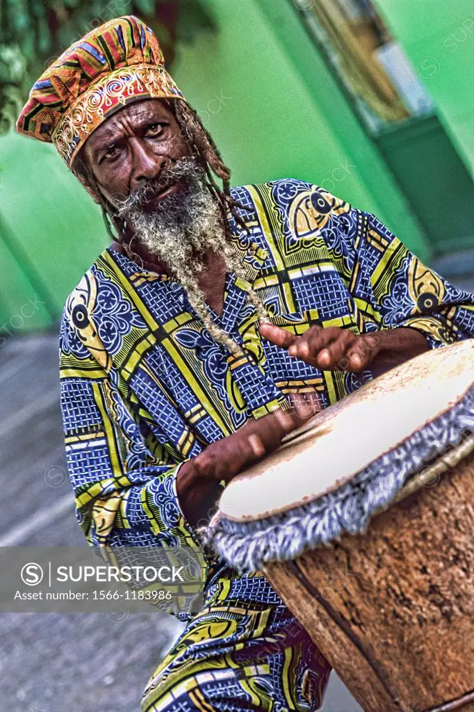 Colorful Rasta Jamaican Reggae performer on drum in costume at Harbour in St John Antigua