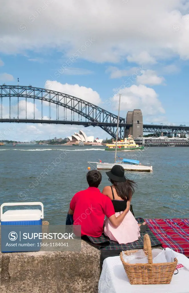 Couple on date at Sydney Harbour with Opera House and Harbour Bridge with skyline in New South Wales Australia