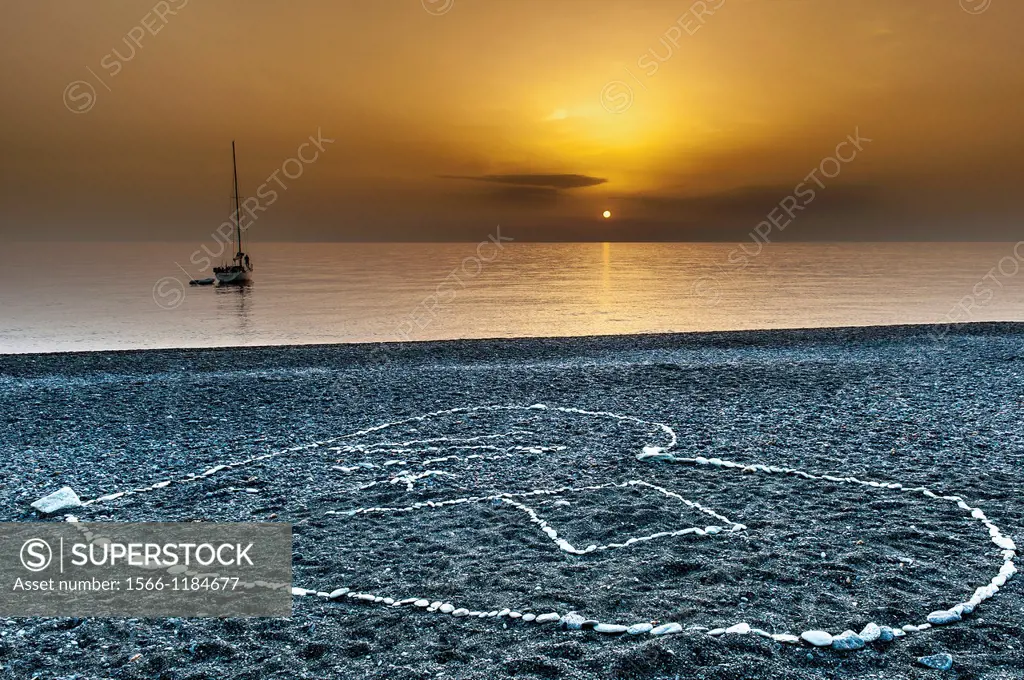 Europe, France, Corse, Haute Corse 2B, Cap Corse. Nonza. Drawing heart shape on the black pebble beach.