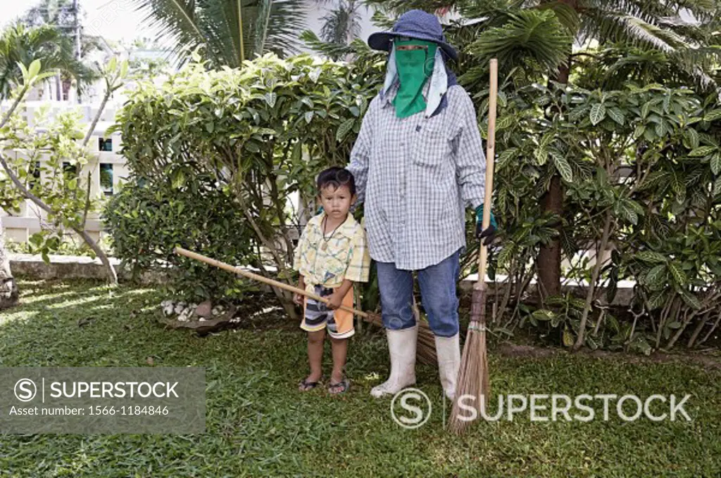 3 year old Thai child helping His mother with the gardening  Thailand S  E  Asia