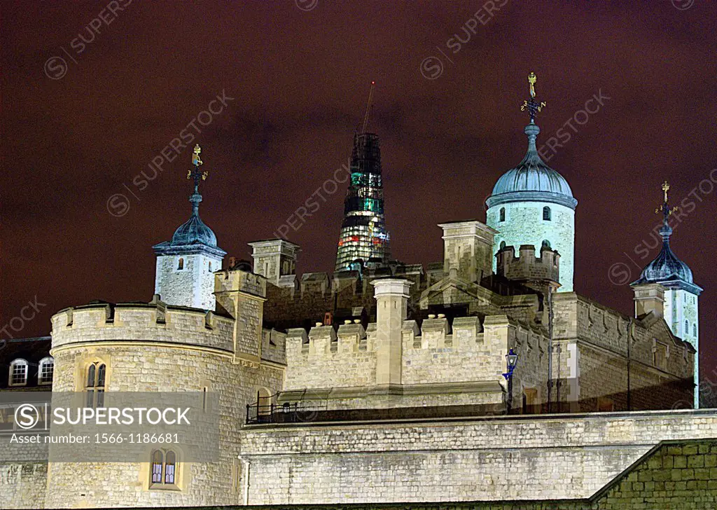North-eastern ramparts of the Tower of London at night with the Shard, Europe´s tallest building, still under construction, seen in the background