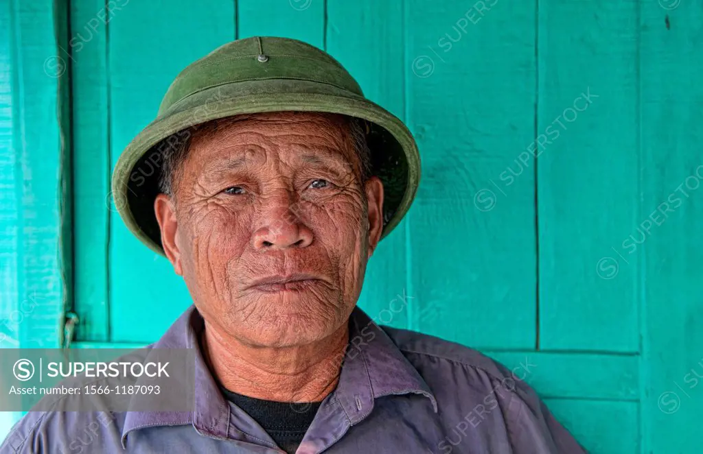 Picturesque scene old man in helmet fishing village Halong Bay Ha Long relax Vietnam