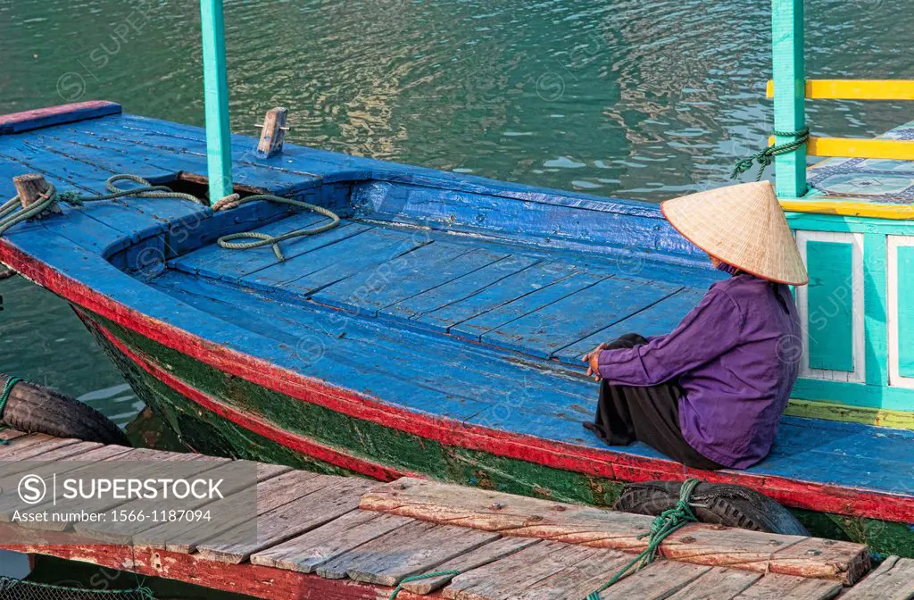 Picturesque scene old woman in purple in fishing village Halong Bay Ha Long relax Vietnam