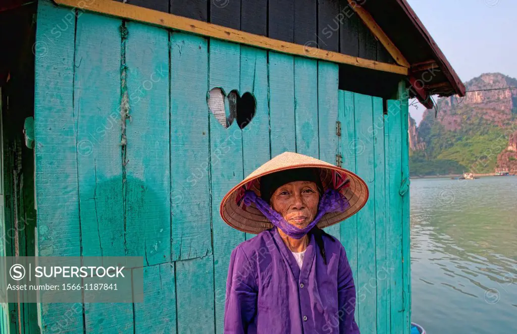 Picturesque scene old woman in purple in fishing village in Halong Bay Ha Long relax Vietnam