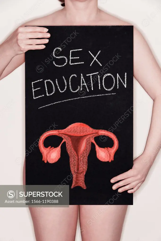 Woman holding a blackboard with SEX EDUCATION and an illustration of the female reproductive system drawn on it in chalk