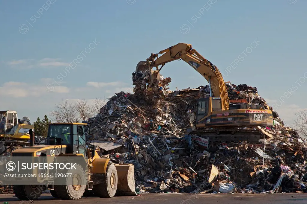 New York, New York - Workers pile debris from Hurricane Sandy in a parking lot next to the beach on Staten Island