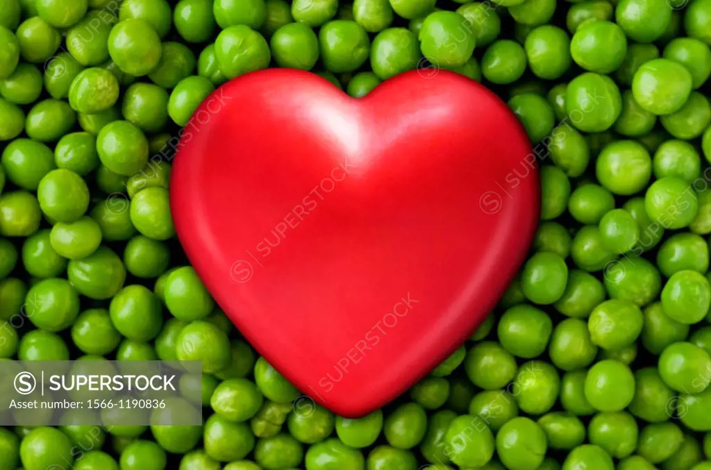 Red heart on fresh green peas  Close up
