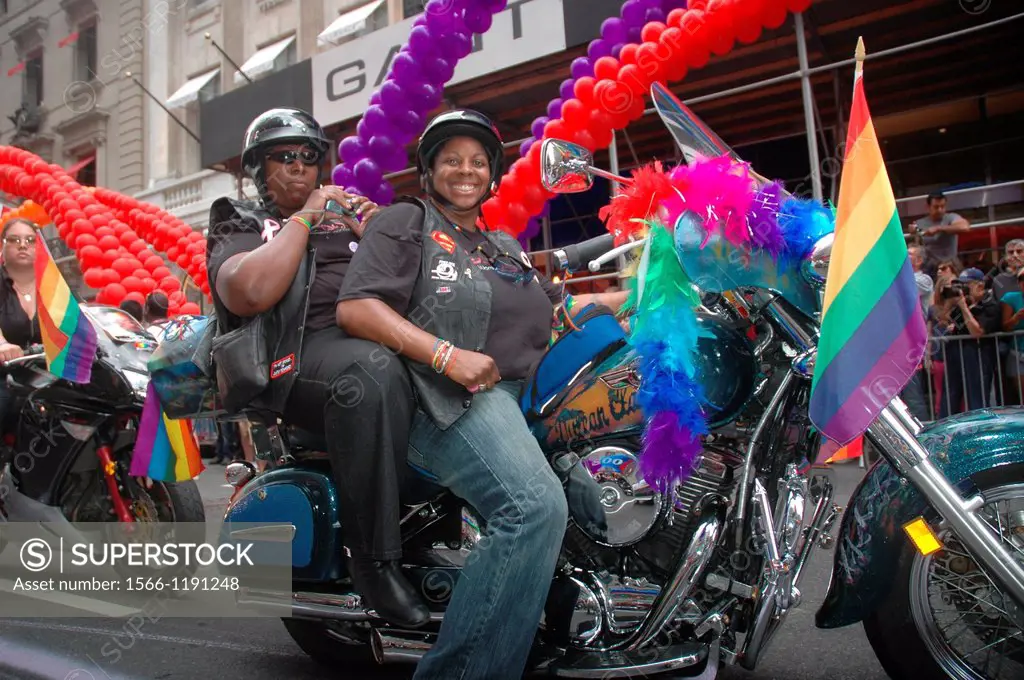 New York City, Manhattan, African-American lesbians on a motorbike at the Gay Pride March June