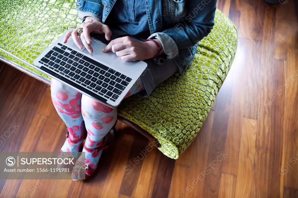 Woman sitting on a chaise longue working with a laptop