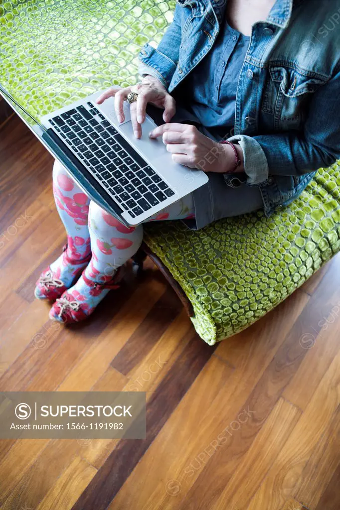 Woman sitting on a chaise longue working with a laptop