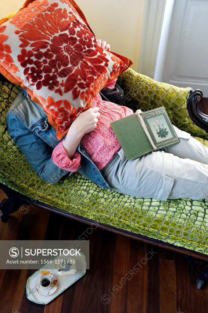mujer con la cara tapada con una almohada tumbada en una chaise longue, woman with her face covered with a pillow lying on a chaise longue