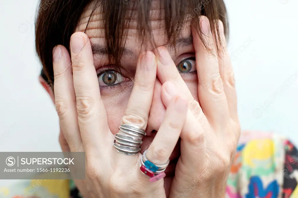 Close-up of woman looking through her fingers