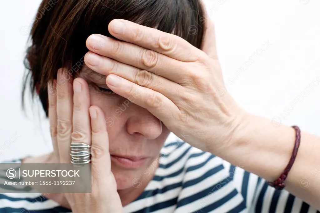 Woman with her hands covering her face worried,