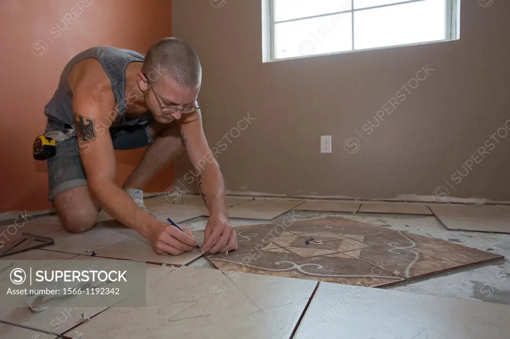 New Orleans, Louisiana - A volunteer with Common Ground Relief lays tile as the organization rebuilds a house for a resident seven years after the cit...