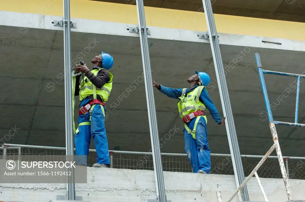 Two men on a high rise construction site, safely harnessed for security
