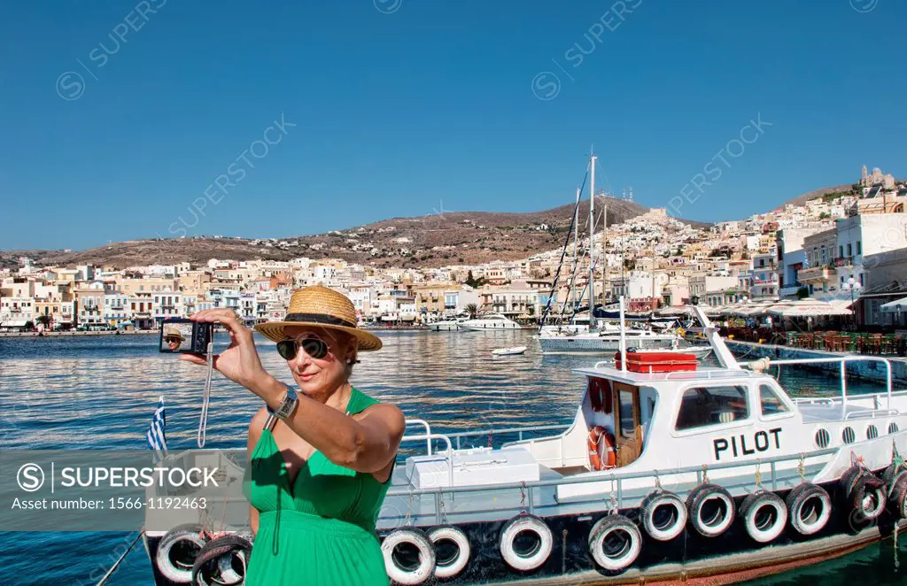 Syros Greece Islands in Hermoupolis capital in marina harbor boats ships port white buildings water boating fishing architecture with tourist lady in ...