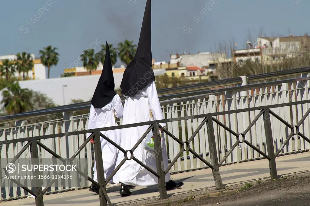 Sevilla Spain  Nazarenes across the bridge of the Expiration in Seville