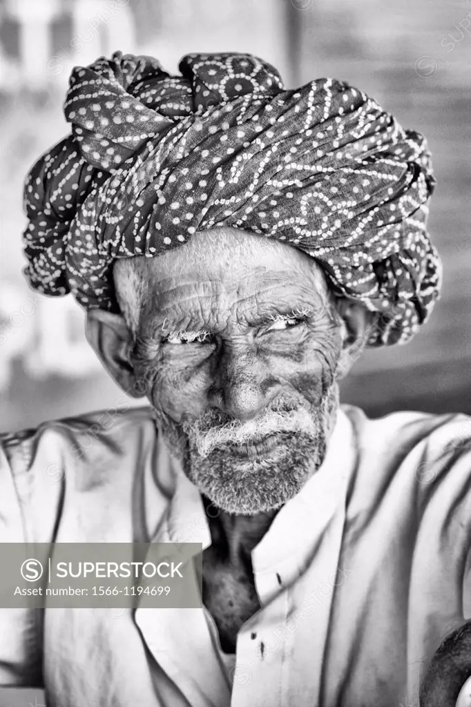 Great colorful portrait of local Hindu old man in turban in small village of Charu near Ranthambore in Rajasthan India
