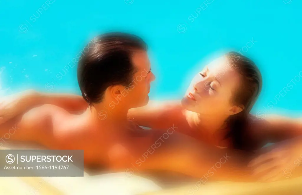 Attractive middle aged couple relaxing in the pool