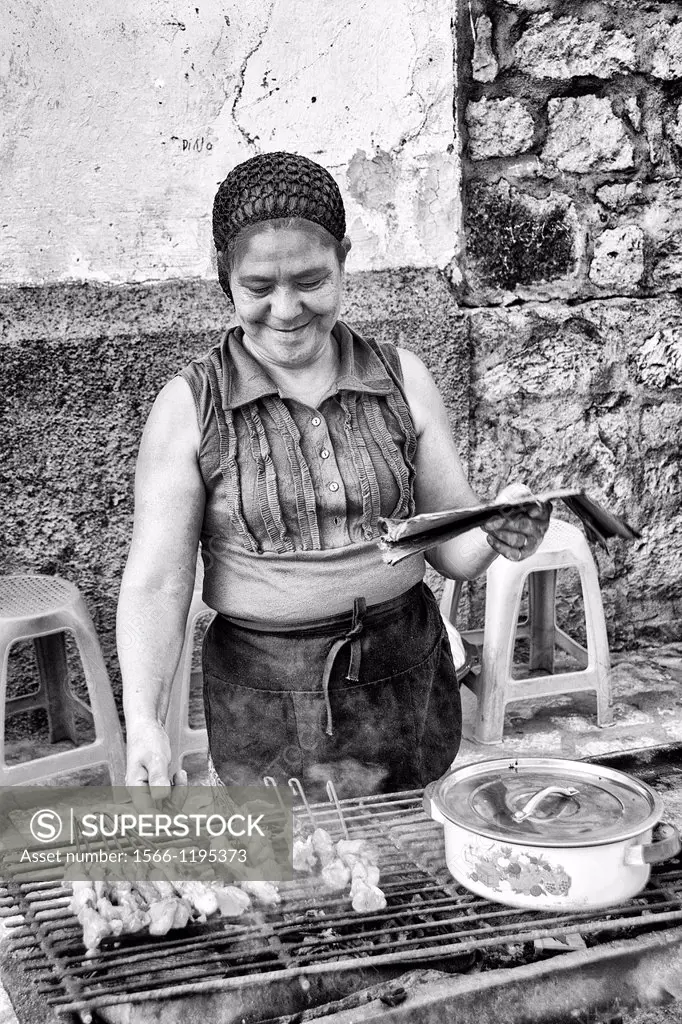 Cooking with local woman on grill for sale in Copan Ruinas Honduras downtown city action