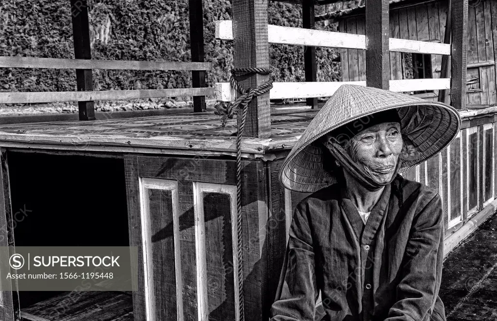 Picturesque scene old woman in purple in fishing village Halong Bay Ha Long relax Vietnam
