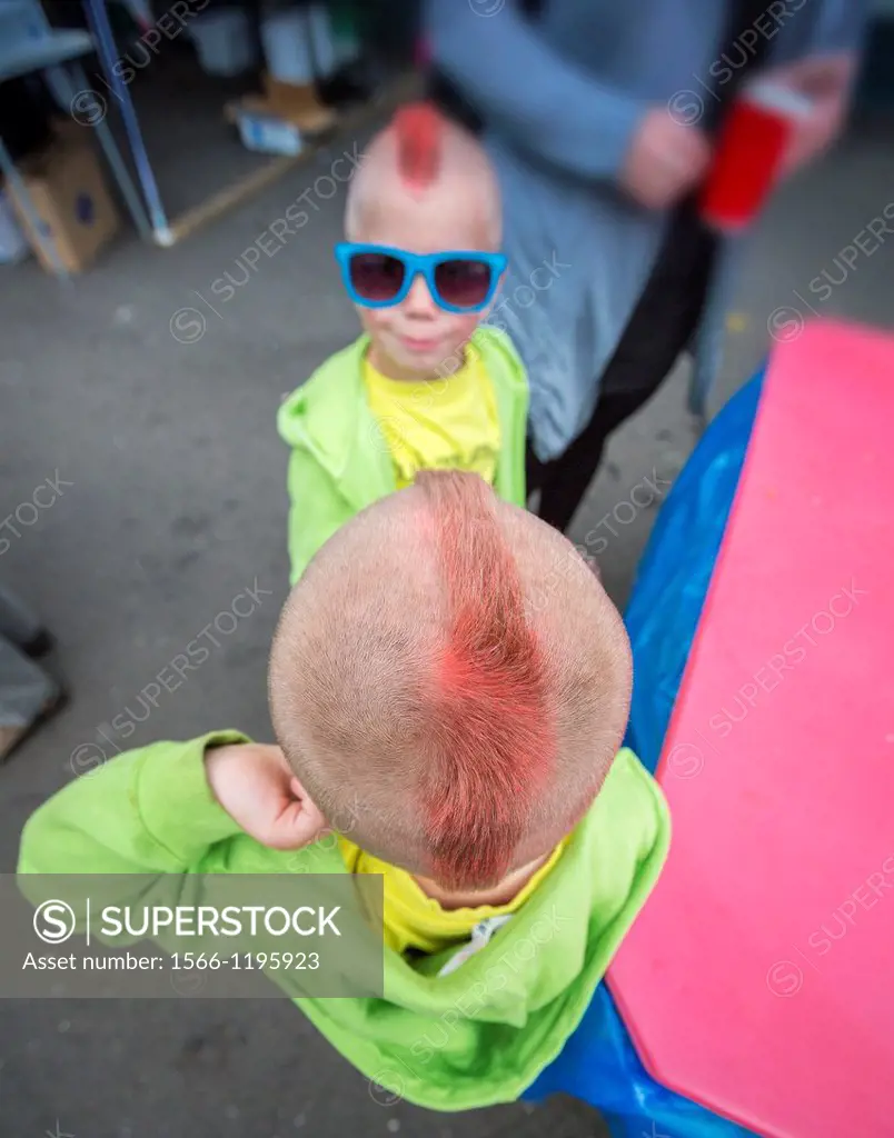 Young twins at a summer festival in Iceland showing off their red mohawks